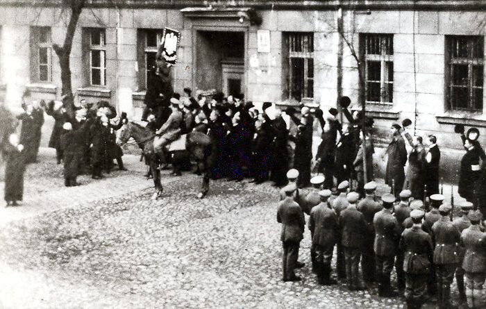 Zdjęcie archiwalne przedstawia moment wieszania polskiego orła na ratuszu w Pleszewie w roku 1919
