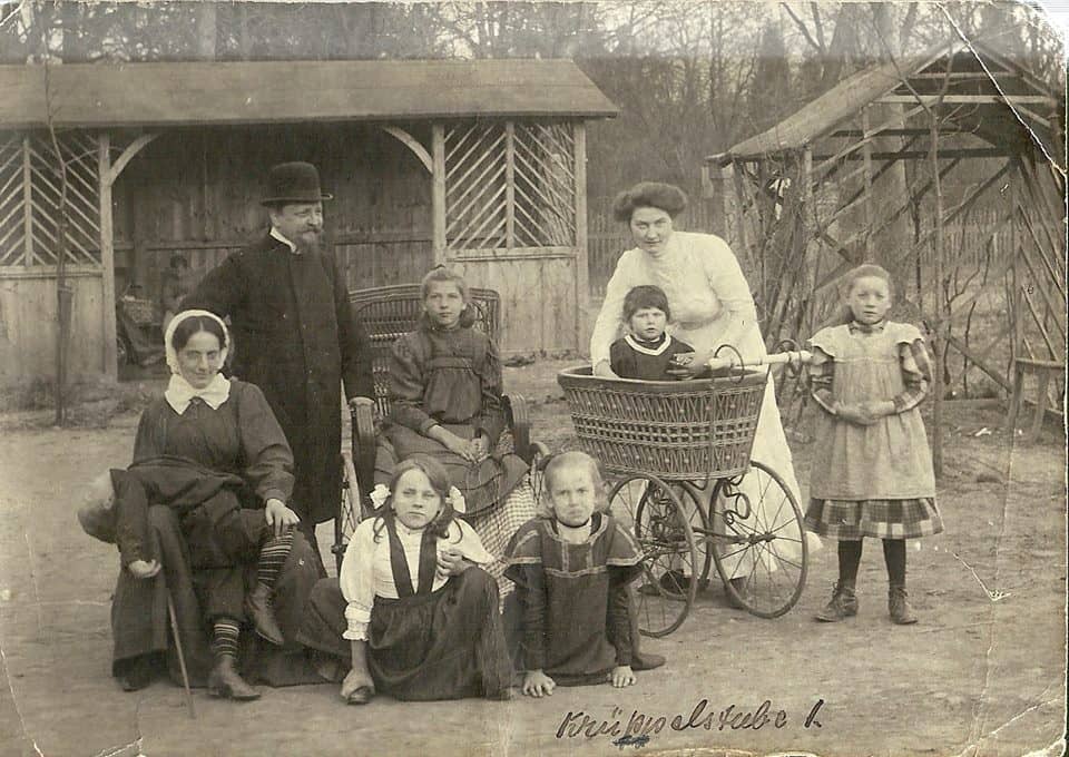 Rodzina z dziećmi stojąca w ogrodzie